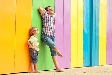 Image showing Father and son relaxing near the house at the day time.