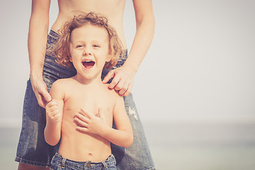 Image showing Mother and son playing on the beach at the day time.