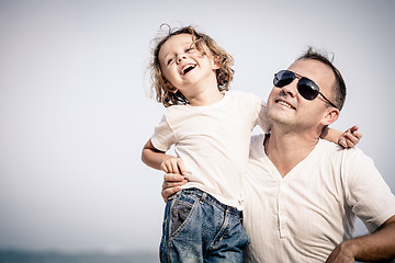 Image showing Father and son playing on the beach at the day time.