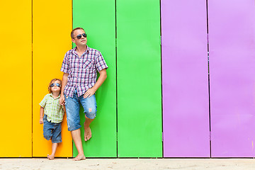 Image showing Father and son relaxing near the house at the day time.