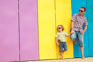 Image showing Father and son relaxing near the house at the day time.