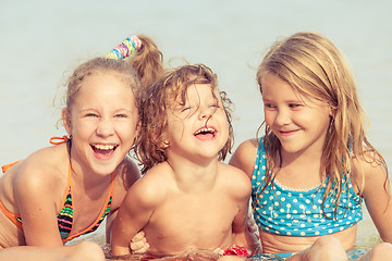 Image showing Three happy children  playing on the beach