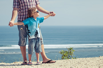 Image showing Father and son playing on the beach at the day time.