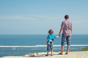 Image showing Father and son playing on the beach at the day time.