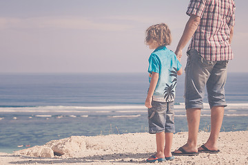 Image showing Father and son playing on the beach at the day time.