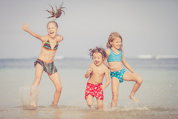 Image showing Three happy children  playing on the beach