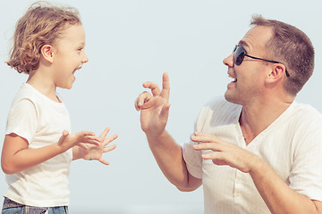 Image showing Father and son playing on the beach at the day time.