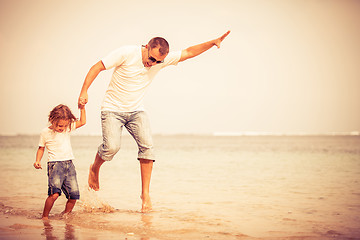 Image showing Father and son playing on the beach at the day time.