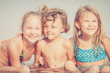 Image showing Three happy children  playing on the beach