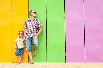 Image showing Father and son relaxing near the house at the day time.