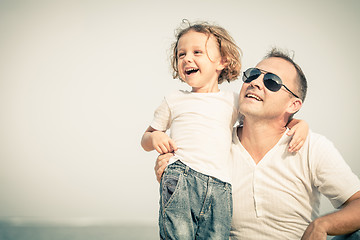 Image showing Father and son playing on the beach at the day time.