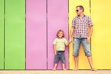 Image showing Father and son relaxing near the house at the day time.