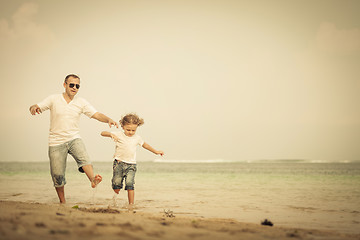 Image showing Father and son playing on the beach at the day time.