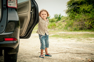 Image showing little boy standing near the car