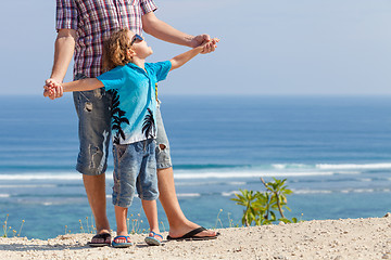 Image showing Father and son playing on the beach at the day time.