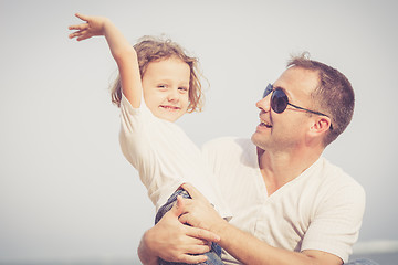 Image showing Father and son playing on the beach at the day time.