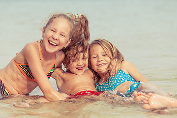 Image showing Three happy children  playing on the beach