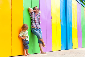 Image showing Father and son relaxing near the house at the day time.