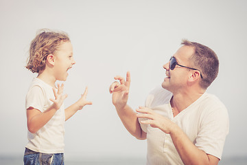 Image showing Father and son playing on the beach at the day time.