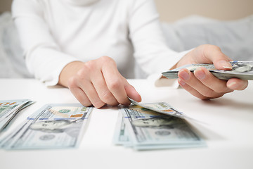 Image showing Close up of woman with calculator counting money