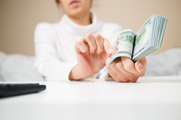 Image showing business, finance, saving, banking and people concept - close up of woman hands counting us dollar money