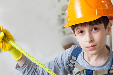 Image showing boy in a protective helmet with a measuring tape