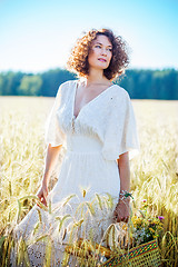 Image showing Beautiful woman dressed in a white dress among the ears in the f