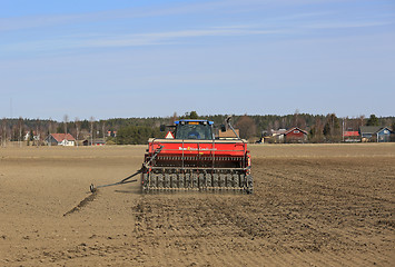 Image showing Tractor and Seeder on Field at Spring