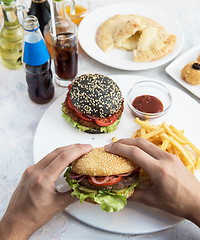 Image showing Man eating burgers