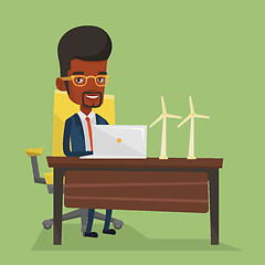 Image showing Man working with model wind turbines on the table.