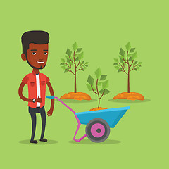 Image showing Man pushing wheelbarrow with plant.