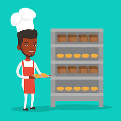 Image showing Happy young male baker holding tray of bread.