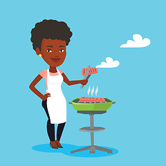 Image showing Woman cooking steak on barbecue grill.