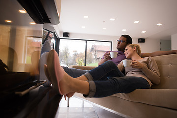 Image showing Young multiethnic couple  in front of fireplace