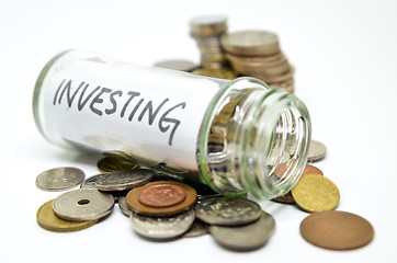 Image showing Investment lable in a glass jar with coins spilling out