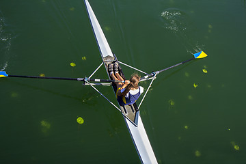 Image showing Young woman rowing in boat on the lake