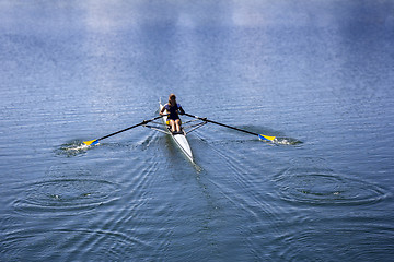 Image showing Young woman rowing in boat on the lake