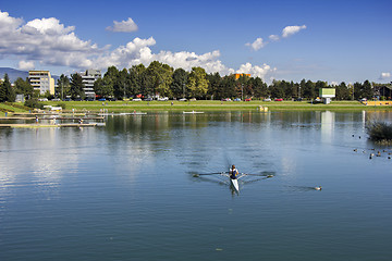 Image showing Young woman rowing in boat on the lake.