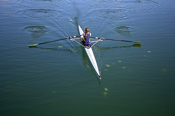 Image showing Young woman rowing in boat on the lake