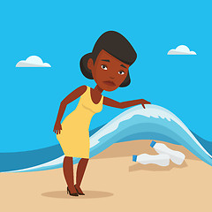 Image showing Woman showing plastic bottles under sea wave.