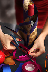 Image showing Satin ribbon. The woman cuts the ribbon with scissors