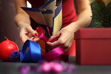 Image showing Things you need to pack gifts Woman packs gifts, step by step Woman packs Christmas gift