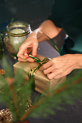 Image showing Packaging holiday gifts. Christmas decorations idea of a handmade gift. Florists, art decoration.