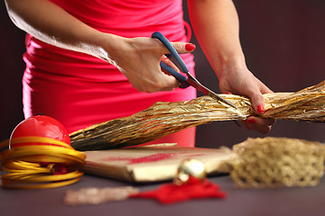 Image showing Satin ribbon. The woman cuts the ribbon with scissors