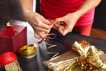 Image showing Satin ribbon. The woman cuts the ribbon with scissors