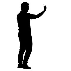 Image showing Silhouettes man taking selfie with smartphone on white background