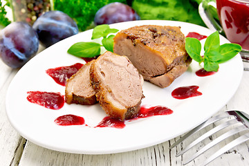 Image showing Duck breast with plum sauce in plate on light board