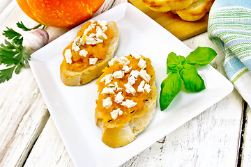 Image showing Bruschetta with pumpkin and cheese in plate on board