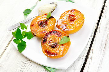 Image showing Quince baked with ice-cream and mint in plate on light board