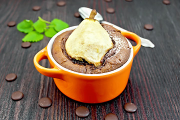 Image showing Cake with chocolate and pear in red bowl on dark board